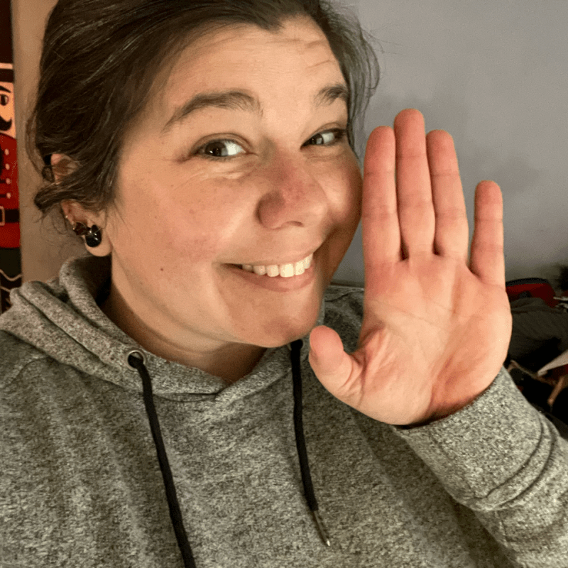 Shannon Tucker Person in gray hoodie smiling and waving at the camera.
